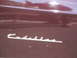 1971 Ford Ranchero - A close-up of a Cadillac script emblem on a maroon vehicle panel.