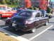 1971 Ford Ranchero - A dark purple sedan is parked in a lot with other vehicles, including a red truck and a hot rod.