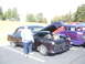 1971 Ford Ranchero - A person stands next to a dark purple coupe with its hood open, parked beside a purple hot rod with flame graphics.