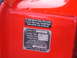 1971 Ford Ranchero - A close-up view of a vehicle's identification plate and a humorous sticker affixed to its red painted surface.