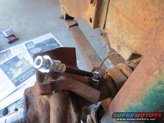 close-up of brake line fitting on rusty suspension part