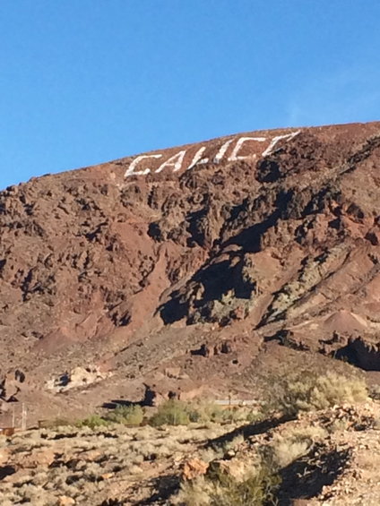 White lettering spelling 'CALICO' on a rocky hillside under a clear blue sky