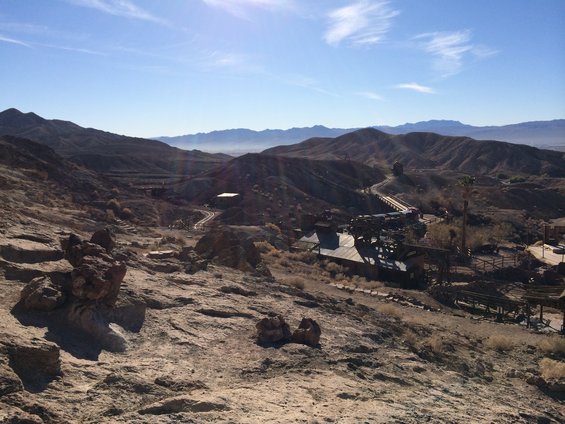Desert landscape with buildings and mountains under a blue sky