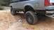 1990 Ford Bronco - This Ford Bronco is shown from the rear quarter on a muddy, off-road trail.