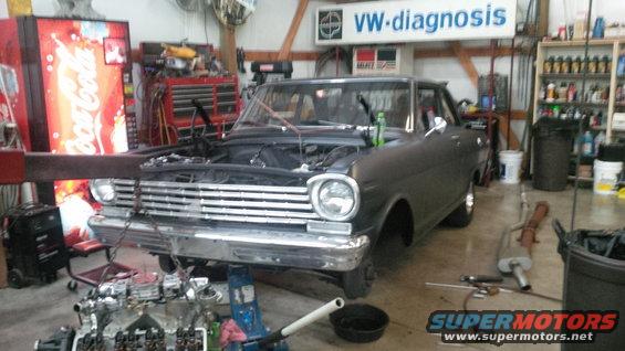 1963 Chevrolet Nova with hood open, engine partially removed, in a workshop