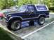 1983 Ford Bronco - This black Ford Bronco features a white removable top and a roof rack for extra storage.