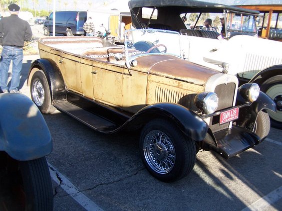Rusty tan touring car with black fenders and chrome wire wheels