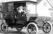 1912 Ford Model T - A 1912 Ford Model T town car is shown with passengers in the enclosed cabin.
