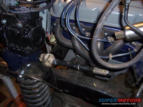 Close-up of engine and steering linkage with exhaust manifold and spark plug wires