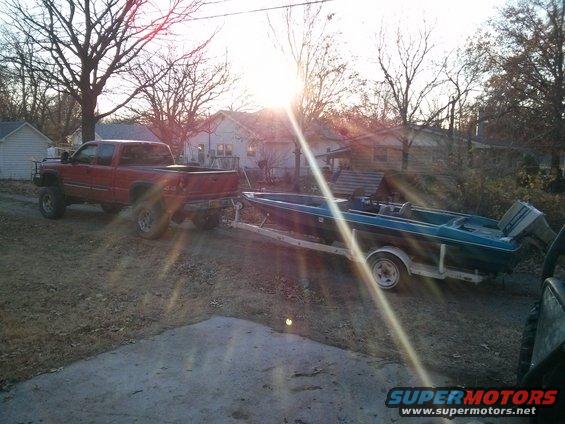 Red pickup truck towing a boat on a trailer