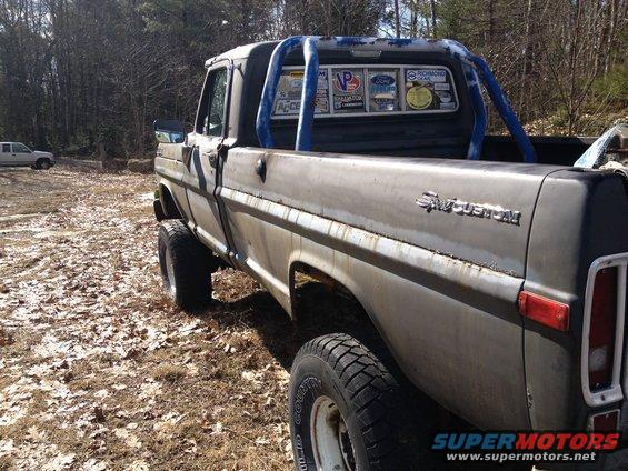 Gray 1970 Ford F-250 with roll bar and stickers on rear window