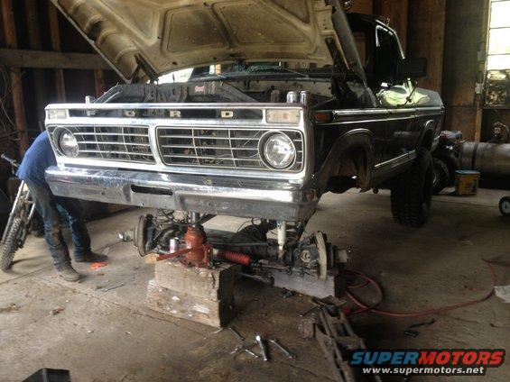 Ford truck front end lifted on blocks with suspension removed for repair. The grille has 'FORD' lettering