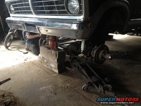 Black Ford F-Series truck front end raised on jack stands, undergoing mechanical work
