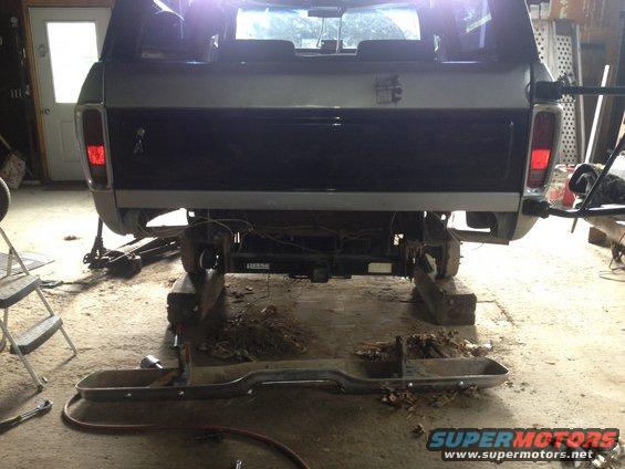 Rear of pickup truck on blocks, bumper removed