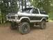 1970 Ford F-250 - This lifted 1978 Ford Bronco is equipped with large off-road tires and auxiliary lights on its roof.