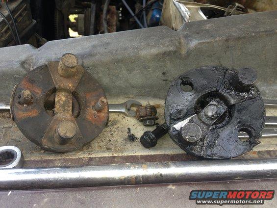 Two steering couplers, one rusty and one greasy, sit on a car's engine bay