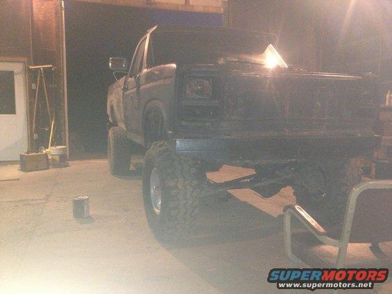 Lifted pickup truck with large tires, parked indoors