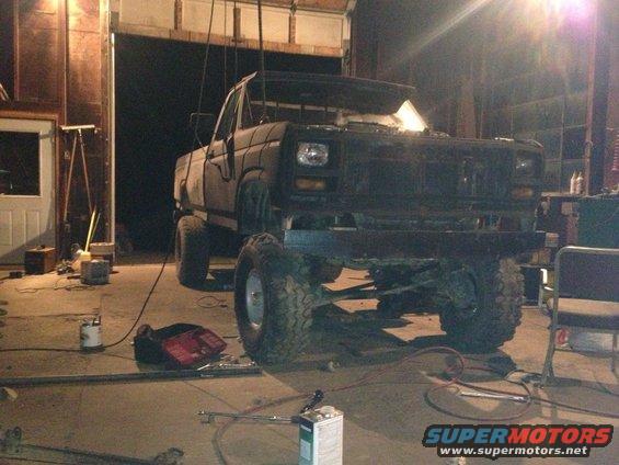 Lifted pickup truck in a garage, looks like it's being worked on