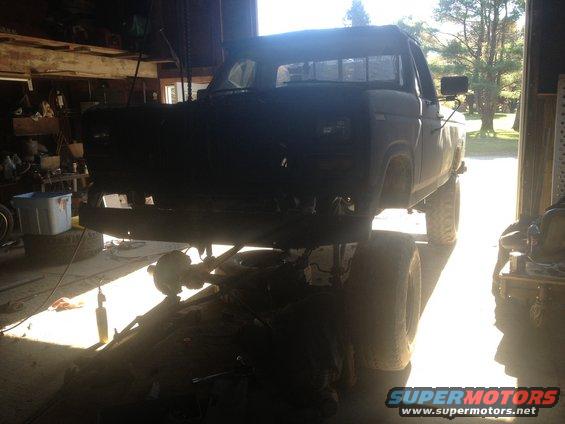 1970 Ford F-250 chassis with front end visible, parked inside a garage