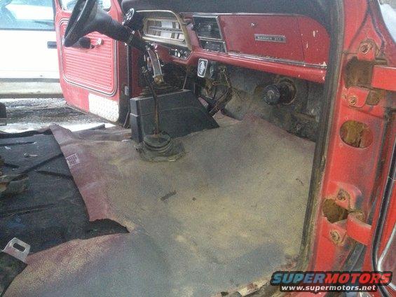Interior of a 1970 Ford F-250 with floor mats removed, showing the dashboard and floor