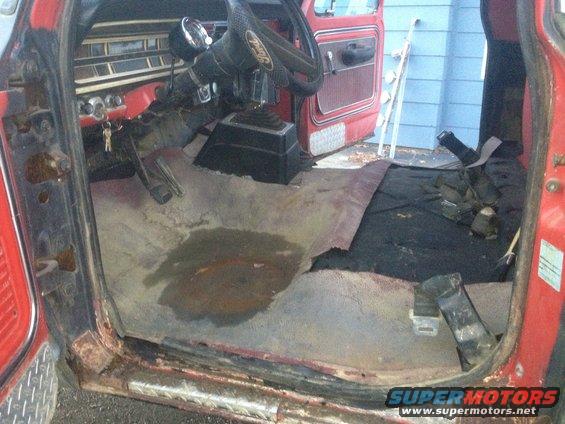 Red Ford F-250 interior with torn carpet, rust on floor, and exposed metal