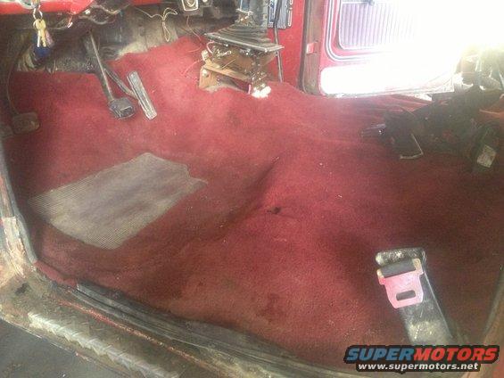 Red carpeted interior with floor shifter and seatbelt