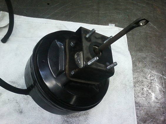 Brake booster with pushrod extended, sitting on a white cloth