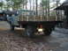 1979 Ford Bronco - Rear view of a flatbed truck with custom wooden bed sides. Likely a 1973 Ford F-Series.