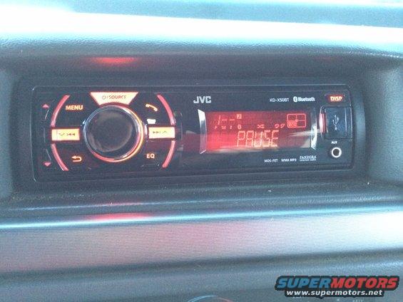 JVC KD-X50BT car stereo with USB and AUX inputs, displaying PAUSE