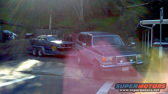 Ford Bronco towing a classic Mustang on a trailer