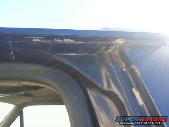 Blue SUV roofline showing rust damage along the rain gutter