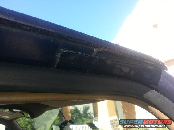 Dark blue vehicle rain gutter with visible rust and damage