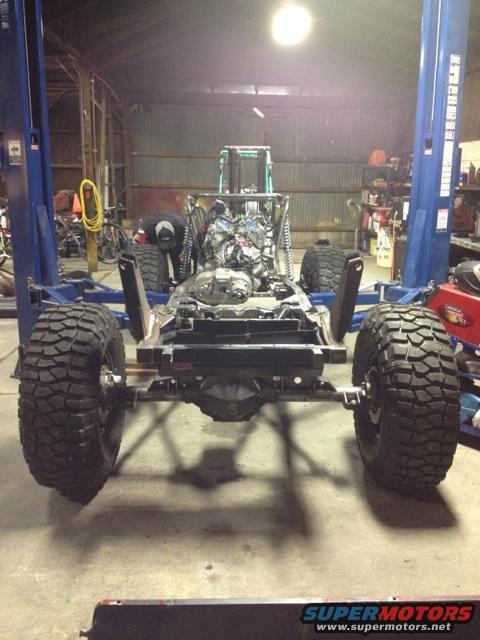 Jeep CJ frame and engine on a lift, undergoing a build