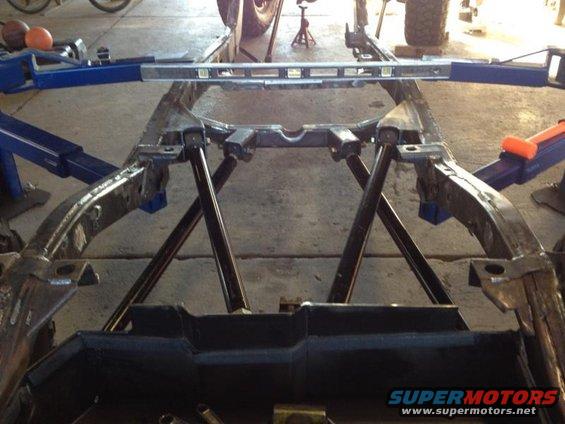 vehicle frame on jack stands with a level on top