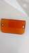 1995 Ford Bronco - This is an orange plastic automotive part, likely a lens or cover, with two visible mounting holes.