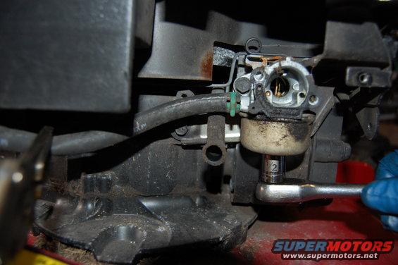 Carburetor with socket wrench attached, close-up