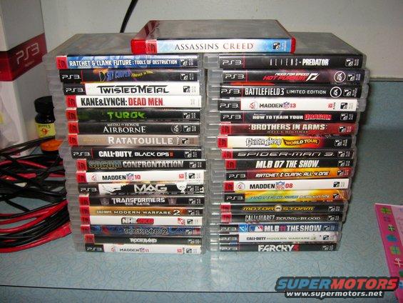 Two stacks of PlayStation 3 video game cases, including titles like Assassin's Creed, Twisted Metal, and Madden