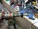 1998 Ford Crown Victoria - A distributor part is held in a gloved hand, with various tools scattered on a workbench in the background.