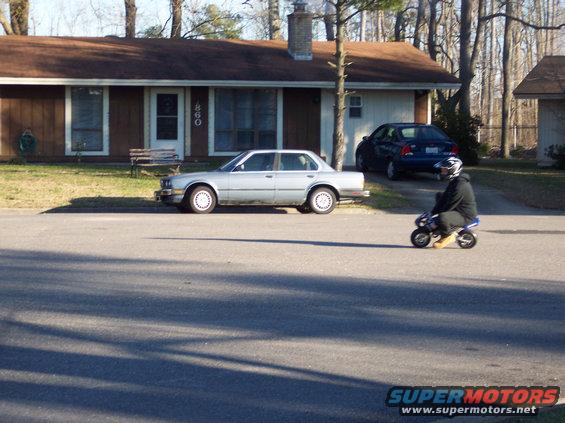 Pocket bike with rider on street in front of house