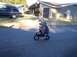 1990 Ford Bronco - Riding a pocket bike on a suburban street with a parked SUV in the background.
