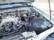 2003 Nissan Frontier - Close-up view of the engine compartment, showing various mechanical components and wiring.