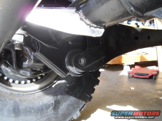 Close-up of vehicle suspension linkage and tire