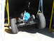 1992 Ford Bronco - The chassis and blue engine of a vehicle are suspended by chains and a yellow gantry in a workshop.