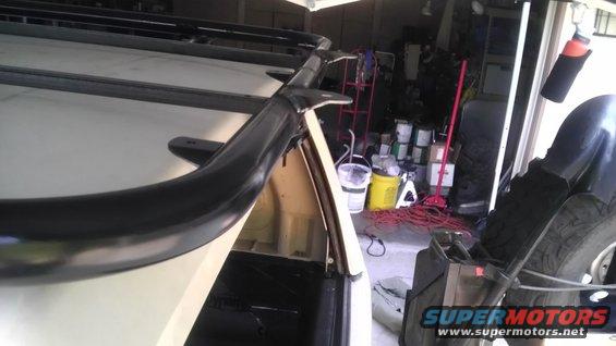 Black roof rack and curved bar on a white vehicle