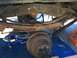 1977 Ford F-350 - Close-up view of a vehicle's rear suspension system, including leaf springs and axle, with repair equipment present.