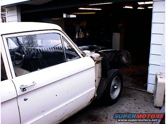 White 1960 Ford Falcon sedan with hood removed, parked in a garage