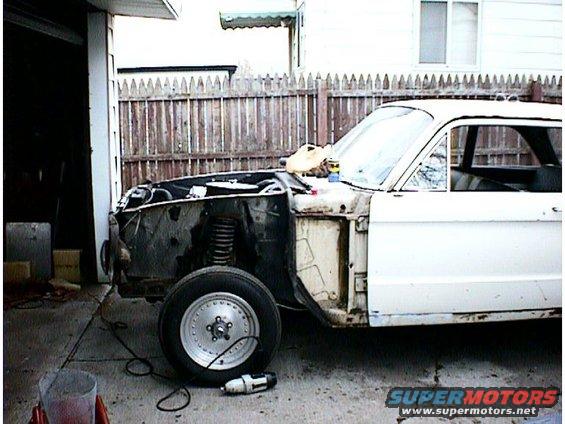 1960 Ford Falcon with front end disassembled, parked outside a garage