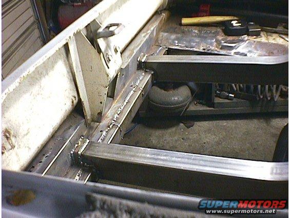 Car frame repair with visible welding and structural reinforcements