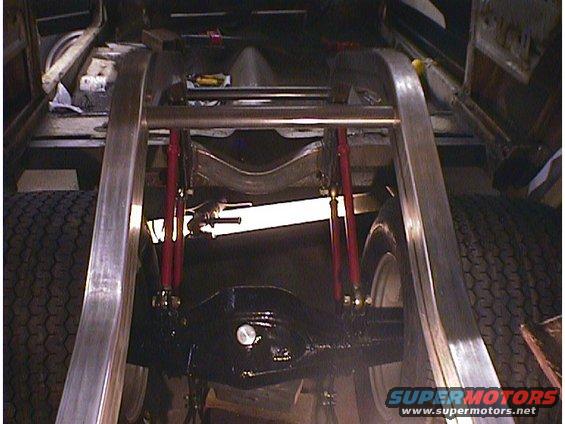 Underbody view of vehicle with red shock absorbers and custom frame