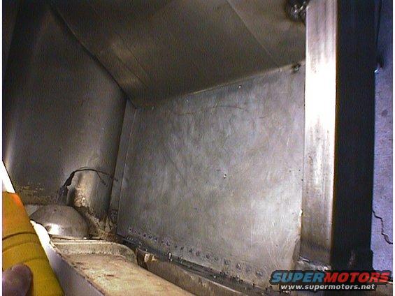 Interior view of riveted metal panels, possibly from a vehicle's trunk or cargo area